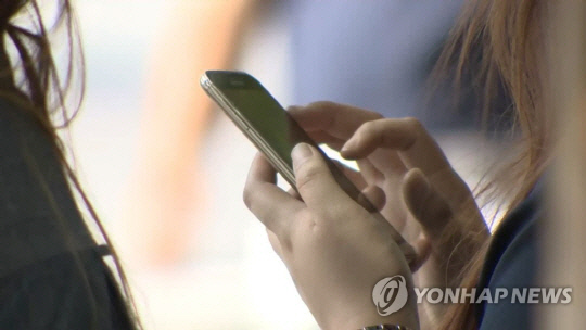 한 여성이 휴대전화를 보고 있다. [연합뉴스 자료사진]